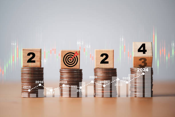 istock Flipping wooden block cube from 2023 to 2024 on coins stacking for setup objective target business cost and budget planing of new year concept. 1460985602