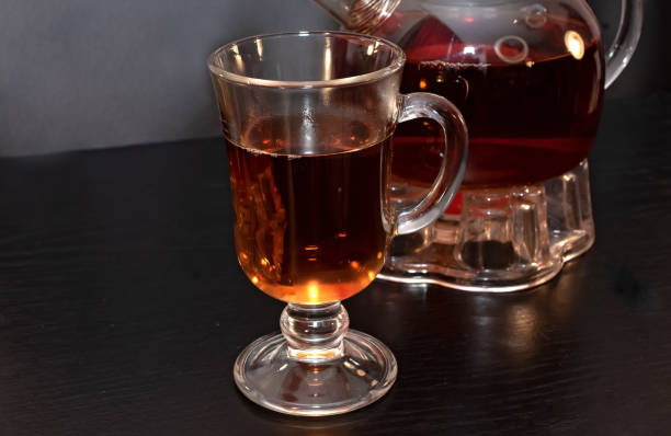 istock Tea in a tall glass and teapot. 1460987431