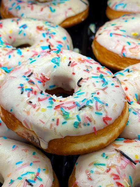 istock Heap of sweet fresh white icing donuts with chocolate in the bakery 1460987529