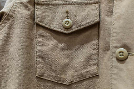 Jacket pocket close-up seam brown button, khaki clothing details
