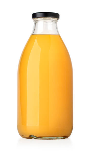 jugo de naranja en una botella de vidrio - zumo de naranja fotografías e imágenes de stock