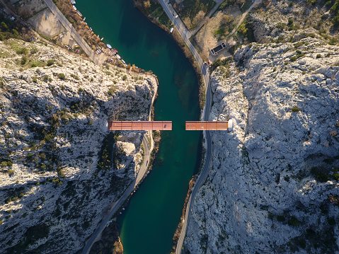 Aerial drone view of Unfinished bridge in Omis, Croatia over the river Cetina. Bridge being built in between the canyon. Industrial and complex construction in the Dalmatia area.