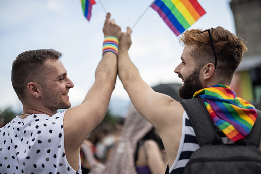 Men waving LGBTQ flags