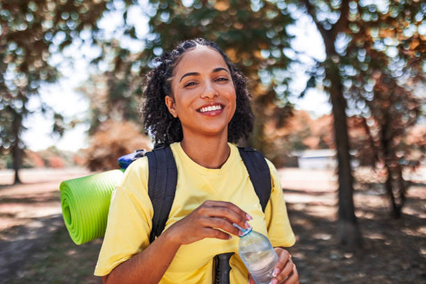 istock Young woman hiking looking at camera hydrating 1460994358