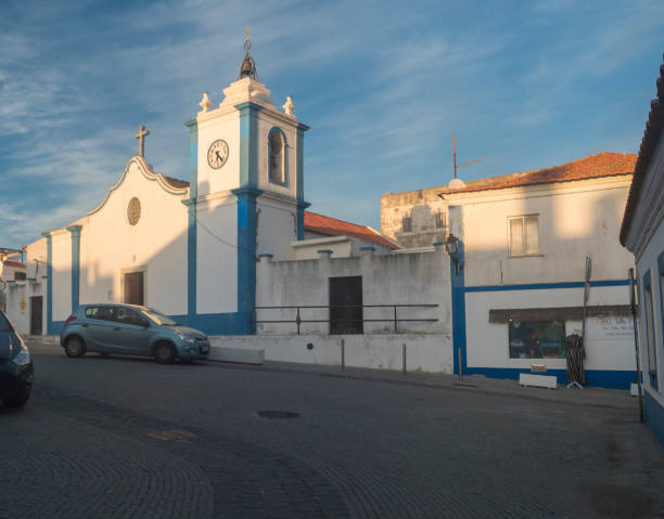 blick auf die kirche igreja paroquial de vila nova de milfontes im traditionellen blau-weißen portugiesischen stil - piazza nova stock-fotos und bilder