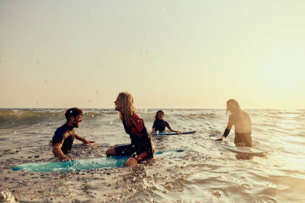 istock Cheerful surfers having fun in sea at sunrise. 1460995574