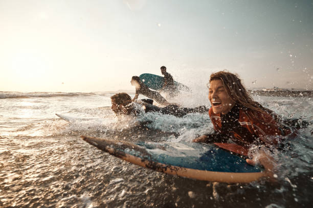 istock Group of cheerful surfers having fun while surfing in sea. 1460995716