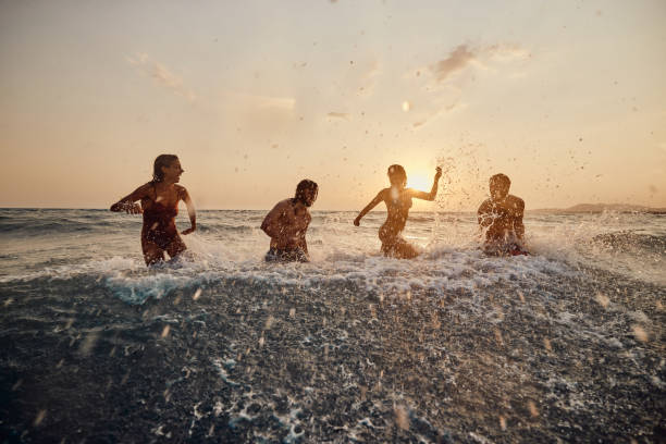 istock Cheerful couples having fun during their summer vacation in sea at sunset. 1460995753