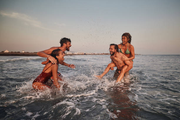 istock Young cheerful couples having fun during summer vacation in sea. 1460995929