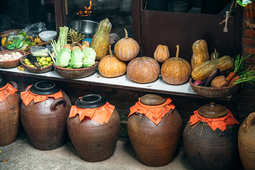 Vietnamese cuisine with huge clay pods in northern Vietnam\nJars of Tuong in ancient house yard, a kind of fermented bean paste made from soybean and commonly used in Vietnamese cuisine