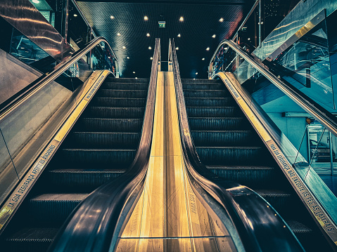 Side by side two ways to go up and down, escalators or stairs