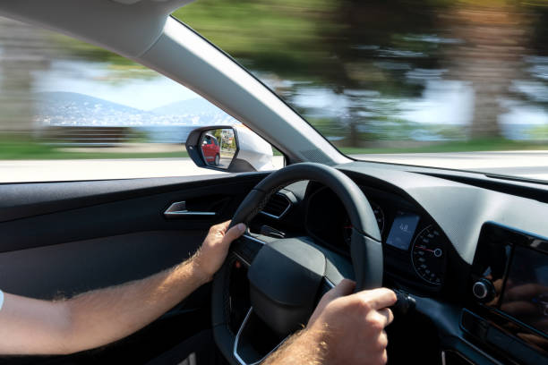 istock Person's hands driving a car with a blurred view from the windows 1461000450