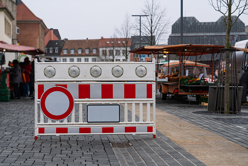 Portable plastic red and white barrier with a stop signal fume resurrecting entry to the peasant market