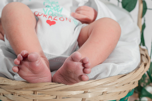 A closeup of a newborn baby's feet in a bamboo fiber basket. Healthy medical concept.