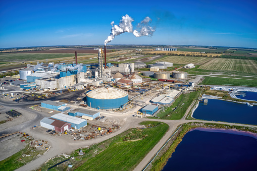 An aerial view of a Sugar Mill Refinery in Rural North Dakota with ponds under a clear sky