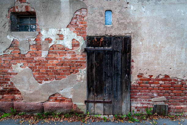 istock Old building facade with a small window and a wooden door 1461002737