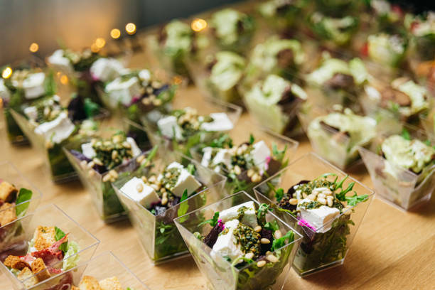 Beet salad with feta cheese cream with pesto sauce and pine nuts. Salads in disposable plastic dishes for a buffet. Catering at an event. Healthy appetizers. stock photo