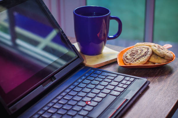 istock Notebook beside pastries, pen, and a cup of coffee on a wooden table - work from home concept 1461003989