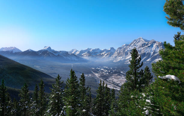 mist covered valley surrounded by mountains and forestry - kananaskis country imagens e fotografias de stock