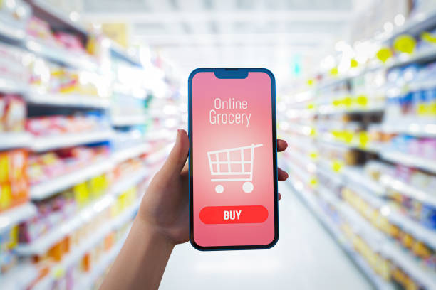 istock hand  holding mobile with grocery online on screen with blur supermarket background. 3D illustration 1461006227