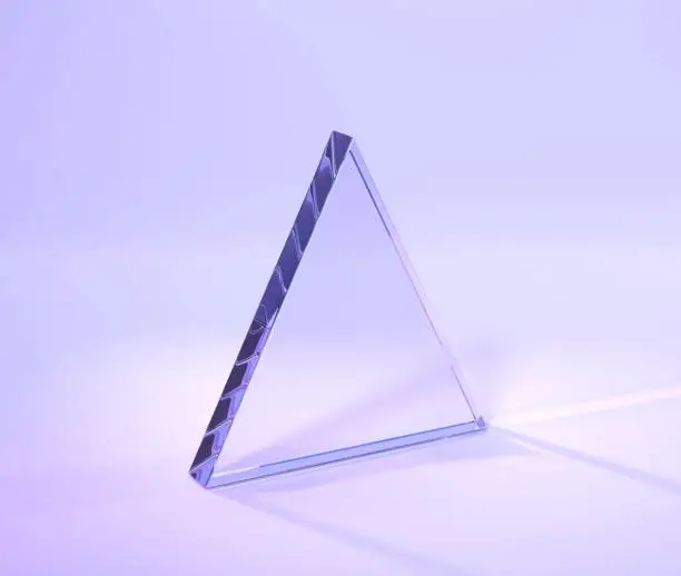 Photo of Glass triangle with rainbow effect of light refraction from prism or crystal 3d render. Clear acrylic plate, glossy panel with lens flare on purple abstract geometric background