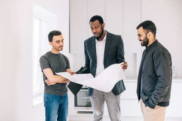 istock Real Estate AGent showing building plans to potential clients 1461010733