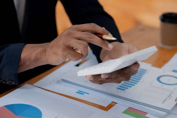 istock Businessman using a calculator to calculate numbers on a company's financial documents, he is analyzing historical financial data to plan how to grow the company. Financial concept. 1461016544
