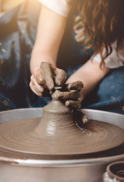 mujer artesana de cerámica haciendo una pequeña olla - throwing wheel fotografías e imágenes de stock