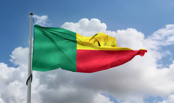 istock Benin flag waving on a pole in a blue sky 1461018474