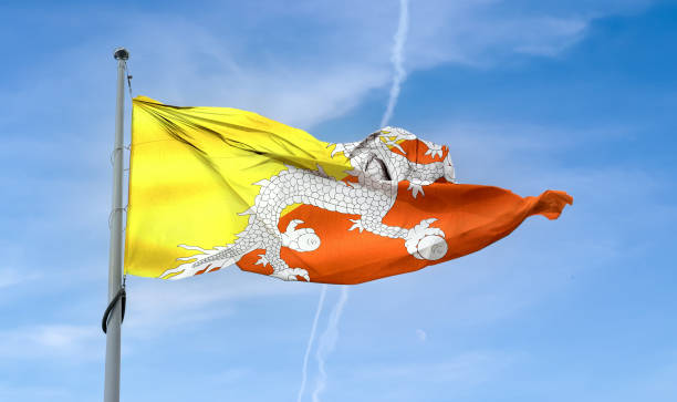 istock Bhutan flag waving on a pole in a blue sky 1461018507