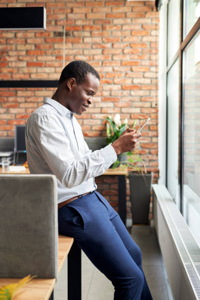 istock Happy young businessman in small office using phone browsing internet 1461018735
