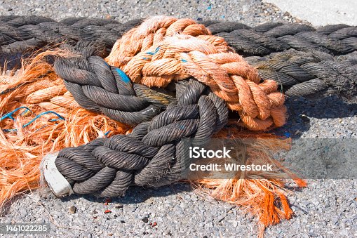 istock Close up of orange and black seafaring ropes on the asphalt ground 1461022285