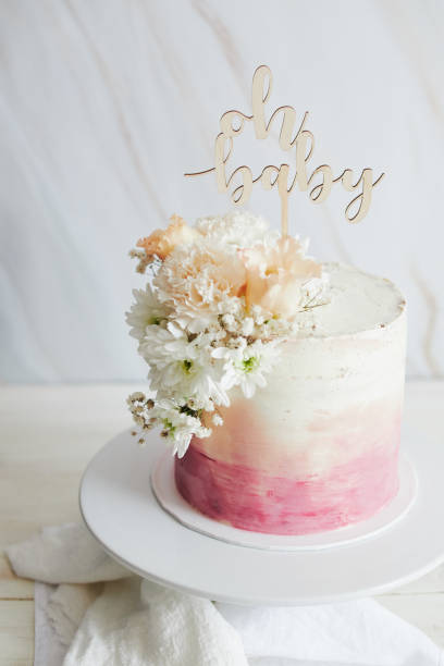 istock Beautiful boho pastel cake with a topper and flowers on a white table 1461022759