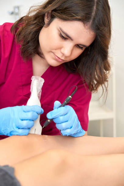 istock Therapist performing a percutaneous electrolysis procedure with an ultrasound machine on the knee. 1461024204