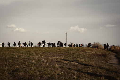 The people standing on the top of the hill.