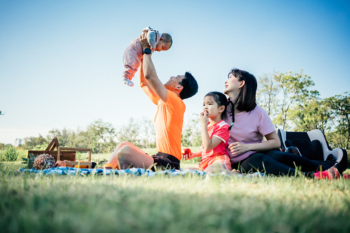 Family relaxing and playing in public park
