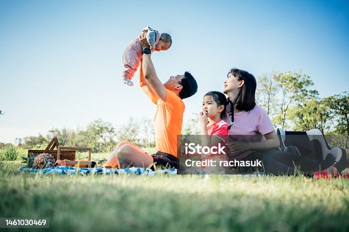 istock Family relaxing and playing in public park 1461030469