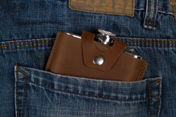 колба на бедрах в кармане джинсов - insulated drink container hip flask alcohol brown стоковые фото и изображения