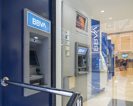 DENIA, ALICANTE (SPAIN) - DECEMBER 15, 2022. Outside and inside ATM's in a BBVA office in the center of Denia (Alicante). BBVA is the second largest bank in Spain. Horizontal composition.