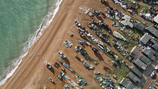 Drone overhead fishing boats on beach Hastings seaside town on Kent coast of England