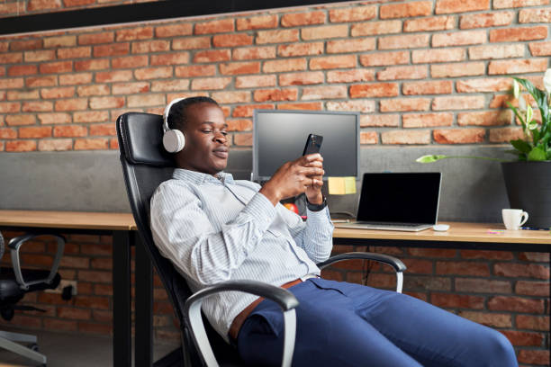 istock Businessman listen to music during break at office work using mobile phone 1461031942