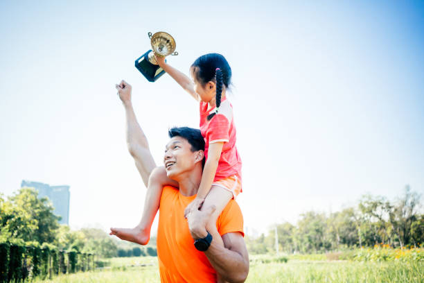 istock Father and daughter celebrating with trophy in hands 1461032914