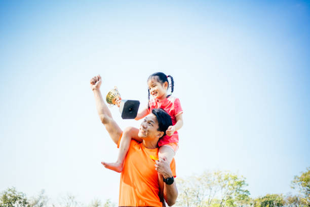 istock Father and daughter celebrating with trophy in hands 1461033059