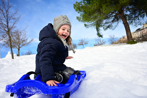 Active winter outdoors games. Winter sleigh ride for children.