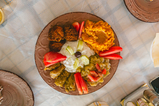 Variety of Greek vegetarian food from above. Fava, tzatziki,eggplant sauce,Dolmadakia, tomato and fried zucchini balls