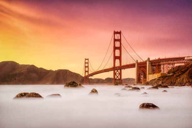 Golden Gate Bridge from Marshall's Beach, San Francisco, California at sunset Long exposure photo in Marshall's Beach with Golden Gate Bridge in the background in San Francisco at sunset, California golden gate bridge stock pictures, royalty-free photos & images