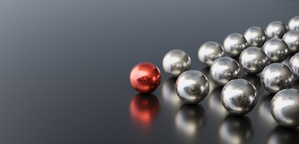 Leadership concept, red leader ball leading silver balls, on black background with empty copy space on left side. 3D Rendering
