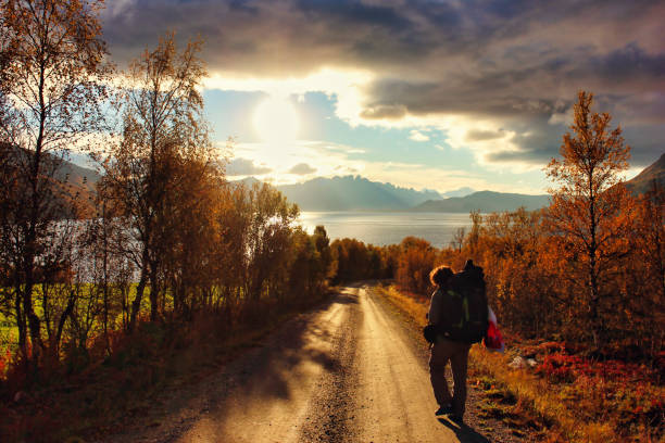 istock Traveler with big backpack walks on a trail at sunset. 1461043397