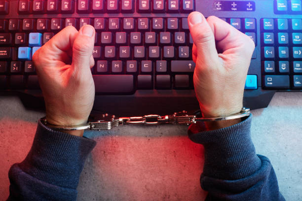 Handcuffed person on computer keyboard, censored journalism, social media censorship concept. Being stuck in a demanding or boring job Handcuffed person on computer keyboard, censored journalism, social media censorship concept. Being stuck in a demanding or boring job censorship stock pictures, royalty-free photos & images