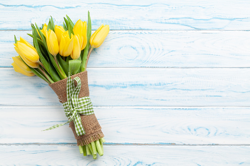 Easter greeting card with yellow tulips bouquet. Top view flat lay with space for your greetings